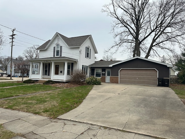 view of front of home featuring covered porch, a garage, and a front lawn