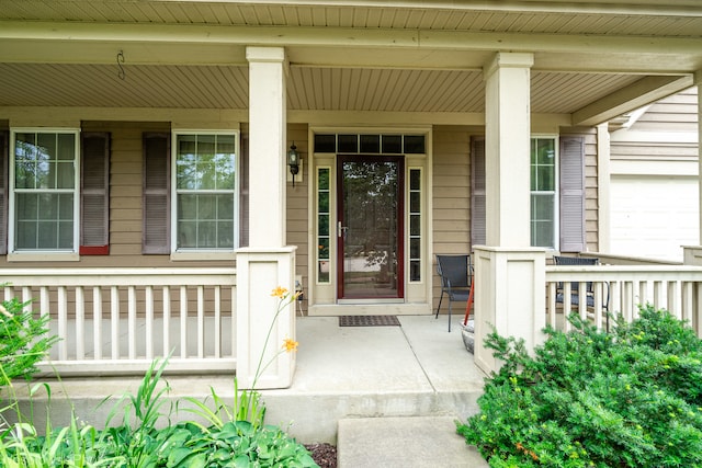 entrance to property featuring a garage and covered porch