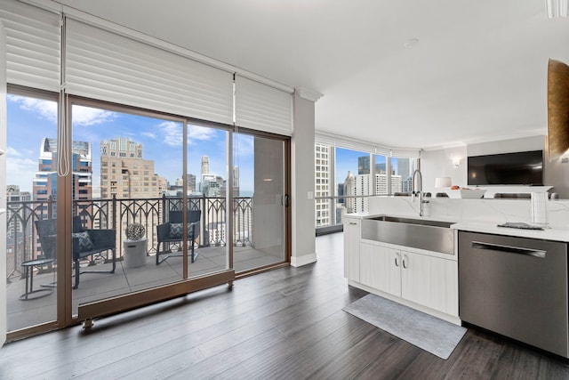 kitchen featuring stainless steel dishwasher, floor to ceiling windows, light stone counters, and sink