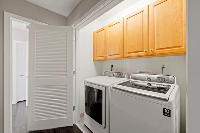 clothes washing area featuring cabinets, dark hardwood / wood-style floors, and washer and dryer