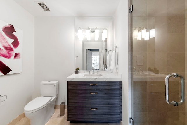 bathroom with tile patterned floors, vanity, toilet, and walk in shower