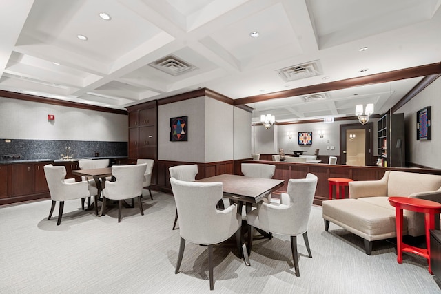 carpeted dining room with beam ceiling, an inviting chandelier, and coffered ceiling