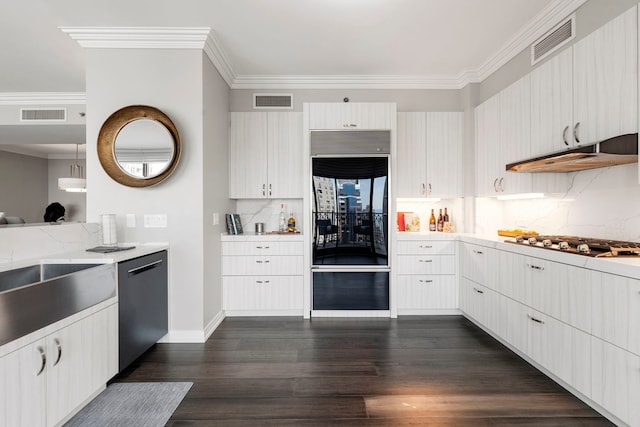 kitchen featuring hanging light fixtures, crown molding, decorative backsplash, appliances with stainless steel finishes, and dark hardwood / wood-style flooring