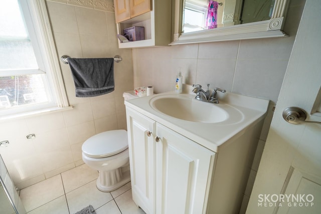 bathroom featuring vanity, tile patterned floors, a wealth of natural light, and tile walls