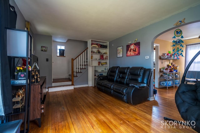 living room featuring wood-type flooring and built in features