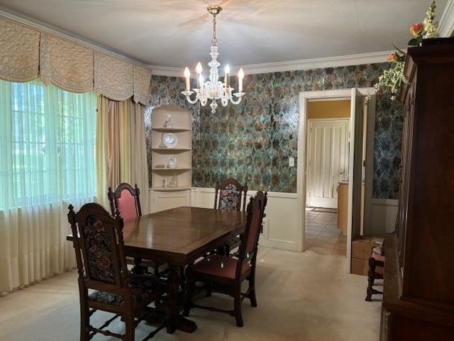 carpeted dining space featuring a notable chandelier and crown molding