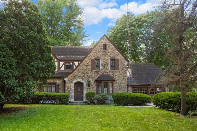 english style home featuring a front yard