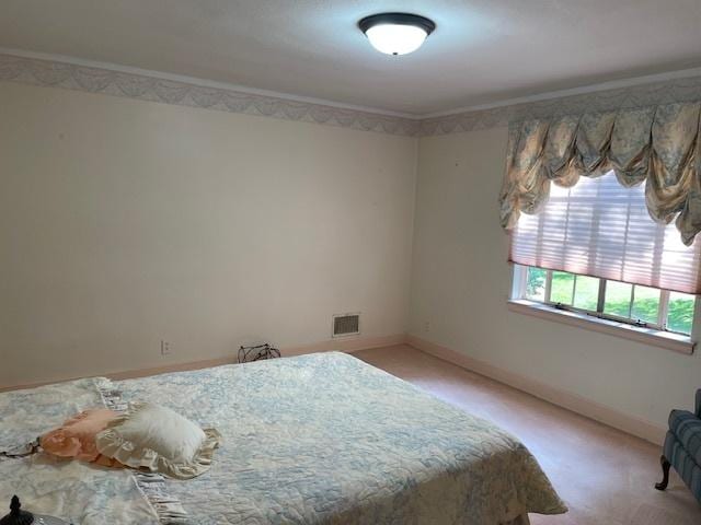 unfurnished bedroom with ornamental molding and light carpet