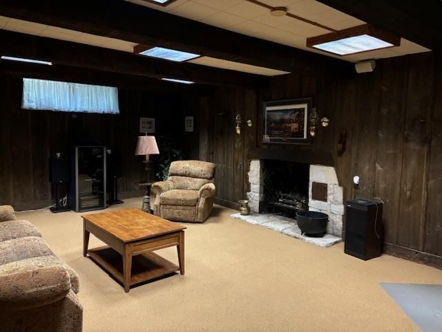 carpeted living room with beamed ceiling and wooden walls