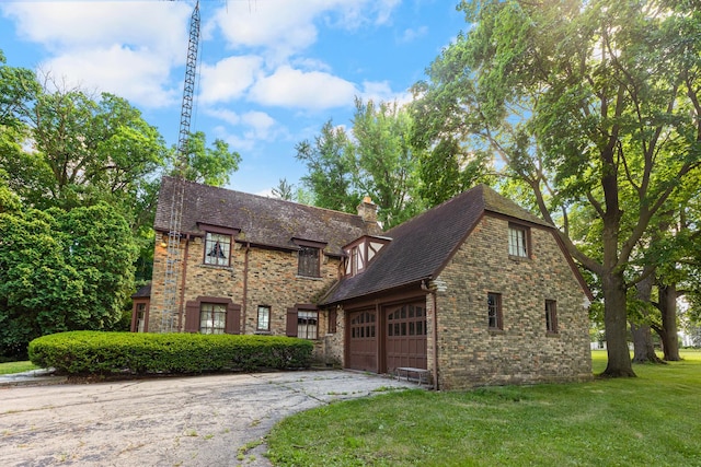 tudor house featuring a garage and a front yard