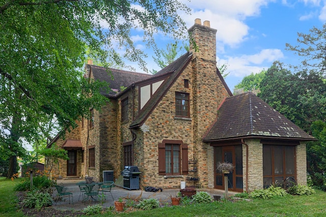 back of house with a patio area and a lawn