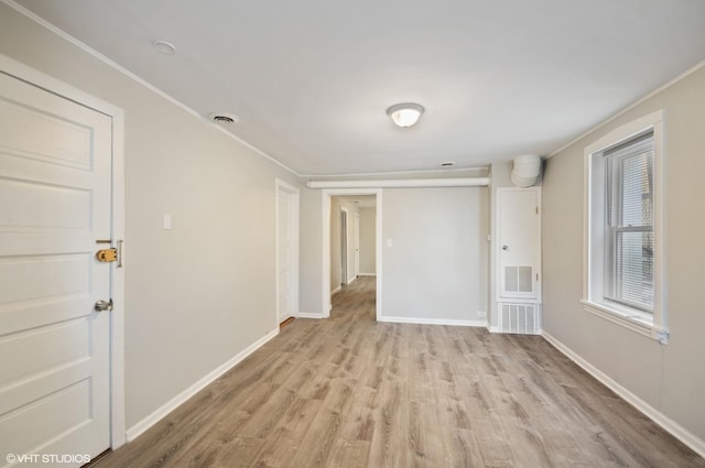 unfurnished room with light hardwood / wood-style flooring and crown molding