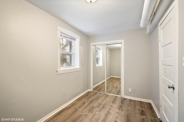 unfurnished bedroom with light hardwood / wood-style flooring and a closet