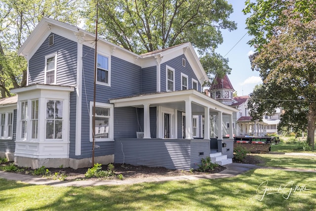 view of side of home with a yard and covered porch