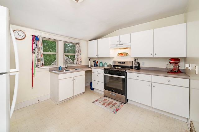 kitchen featuring white cabinetry, stainless steel gas stove, vaulted ceiling, sink, and light tile floors