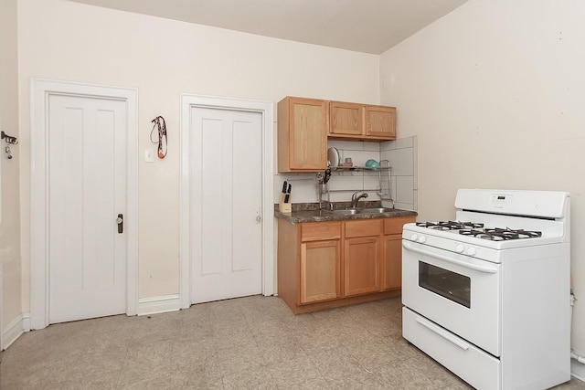 kitchen with white gas range and sink