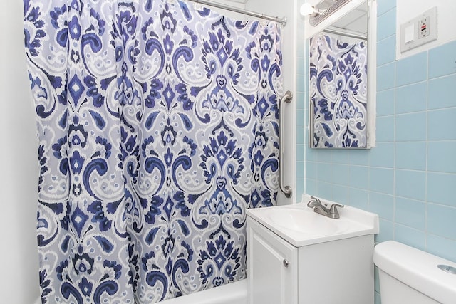 bathroom featuring vanity, toilet, tile walls, and curtained shower