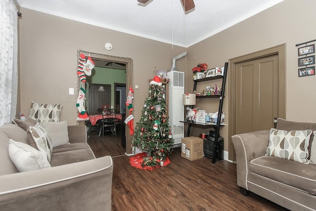 living room with ceiling fan, dark wood-type flooring, and a textured ceiling