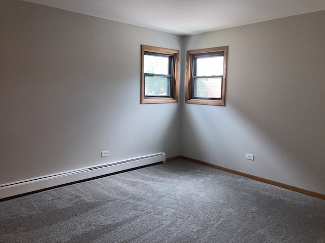 unfurnished room with carpet and a baseboard radiator