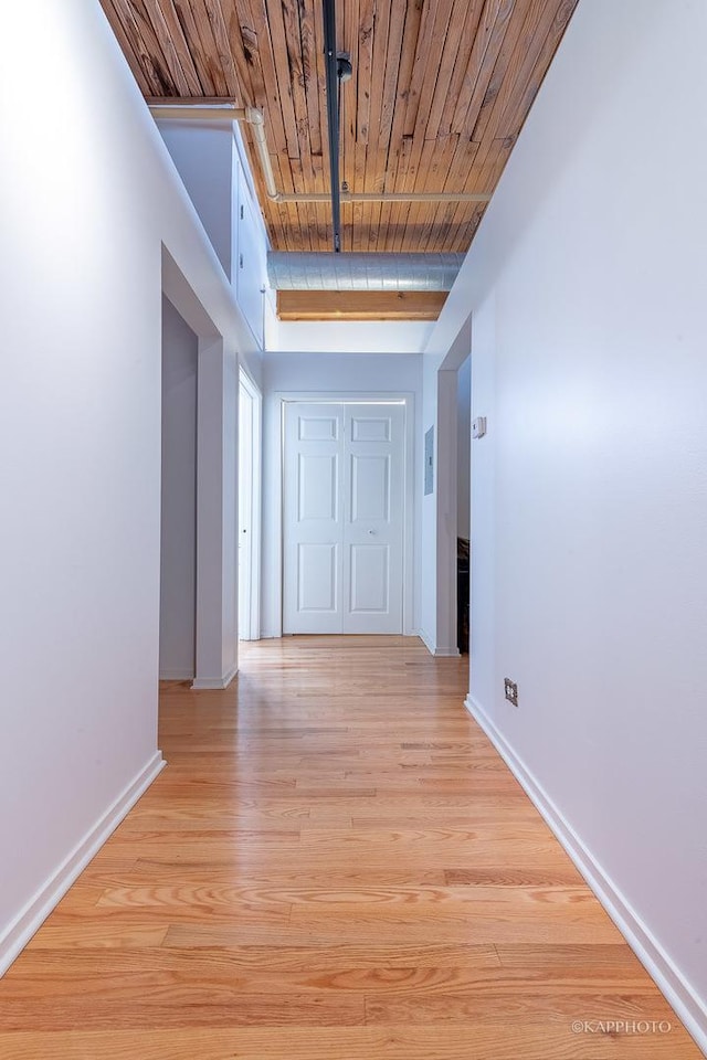 hallway featuring light hardwood / wood-style flooring, beamed ceiling, and wooden ceiling