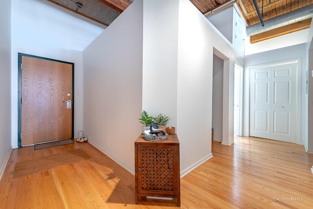 foyer with light wood-type flooring and a towering ceiling