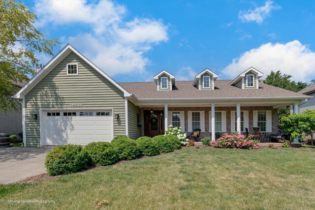 cape cod house featuring a garage, covered porch, and a front yard