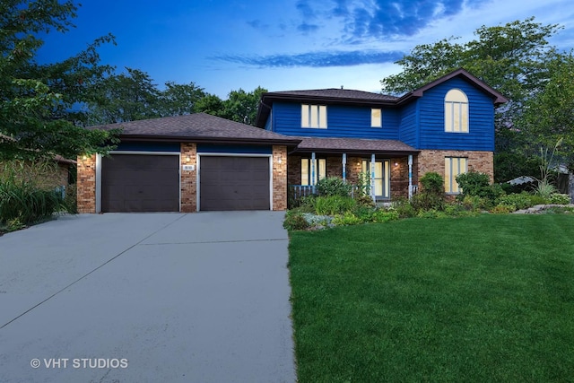 traditional home featuring a front yard, brick siding, driveway, and an attached garage