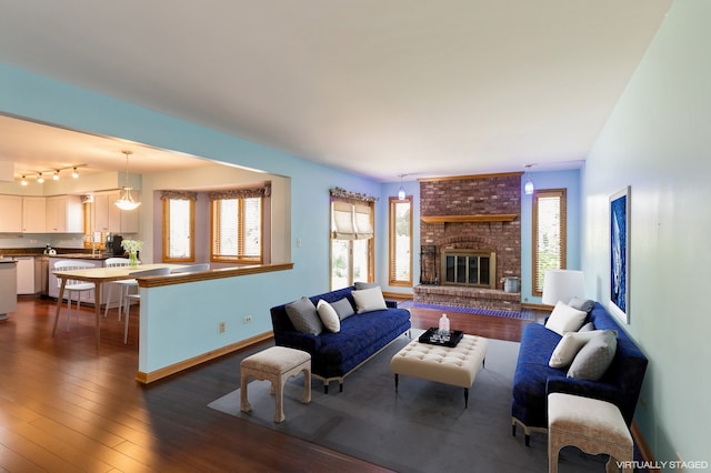 living room featuring dark hardwood / wood-style flooring and a brick fireplace