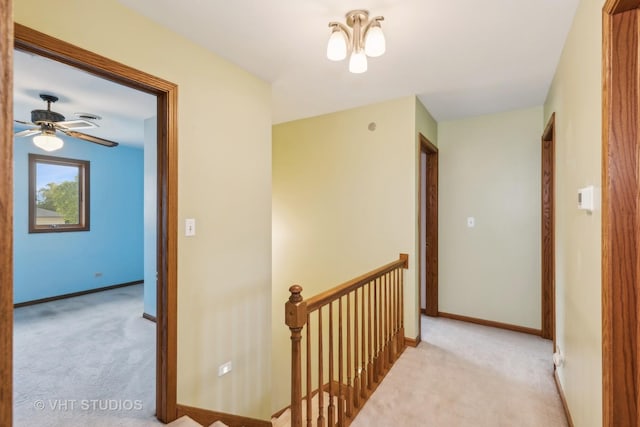 hall with baseboards, carpet flooring, and an upstairs landing