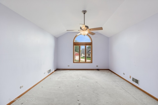 empty room with lofted ceiling, ceiling fan, and light carpet