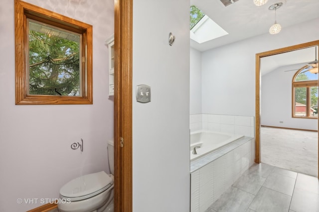 full bathroom with visible vents, toilet, tile patterned flooring, vaulted ceiling with skylight, and a bath