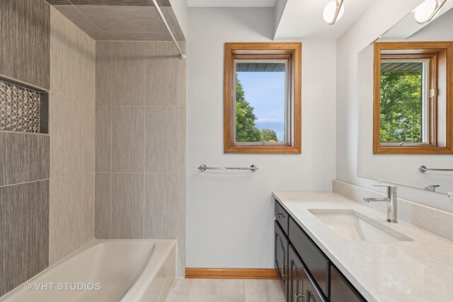 bathroom featuring tiled shower / bath and vanity