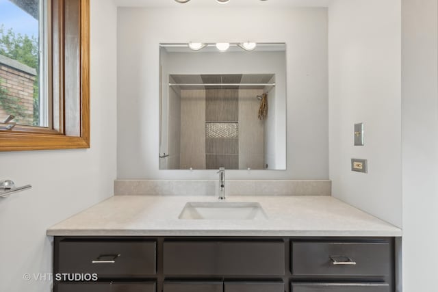 bathroom with walk in shower and vanity