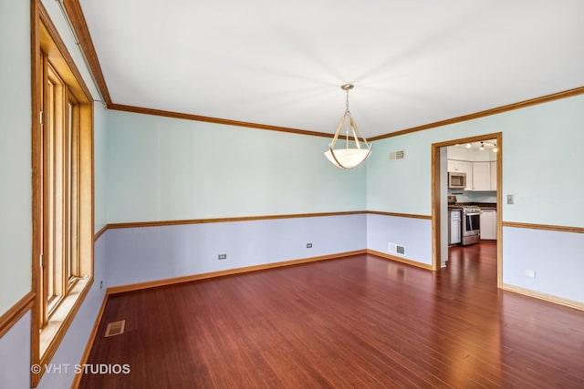 unfurnished room featuring dark wood-style floors, visible vents, crown molding, and baseboards