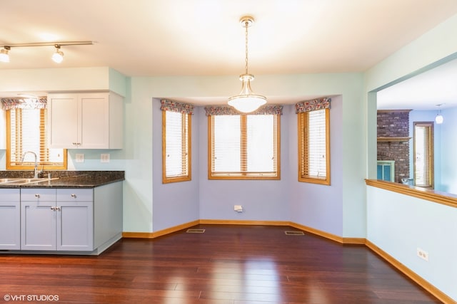 kitchen with a healthy amount of sunlight, sink, white cabinets, and dark hardwood / wood-style floors