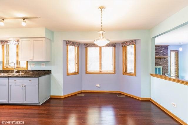 kitchen with visible vents, baseboards, dark wood finished floors, and a sink