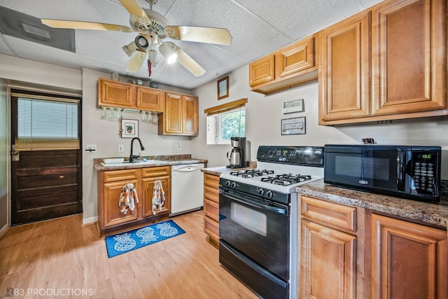 kitchen featuring ceiling fan, sink, black appliances, and light hardwood / wood-style flooring