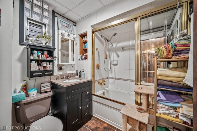 full bathroom featuring tile patterned floors, a paneled ceiling, vanity, tiled shower / bath combo, and toilet