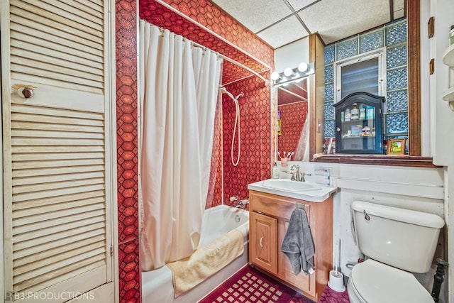 full bathroom with a paneled ceiling, vanity, toilet, and shower / bathtub combination with curtain