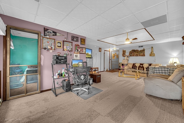 carpeted office space featuring a paneled ceiling and ceiling fan