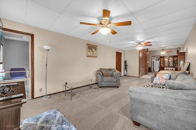 living room with a drop ceiling and light carpet