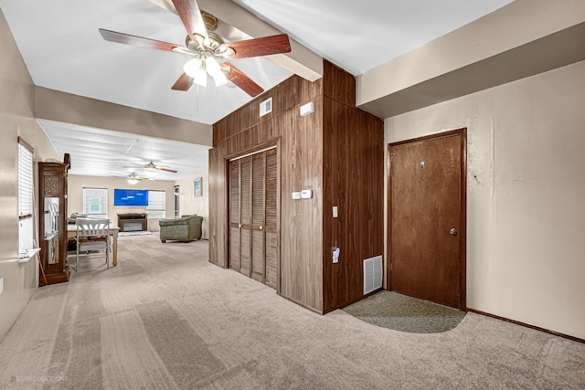 corridor featuring wood walls, light carpet, and vaulted ceiling with beams