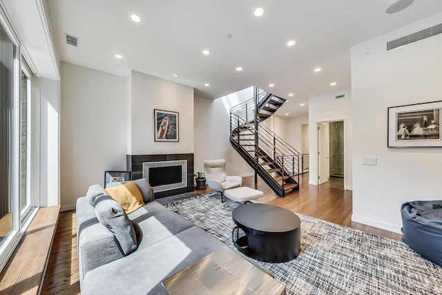 living room featuring dark hardwood / wood-style flooring and a tiled fireplace