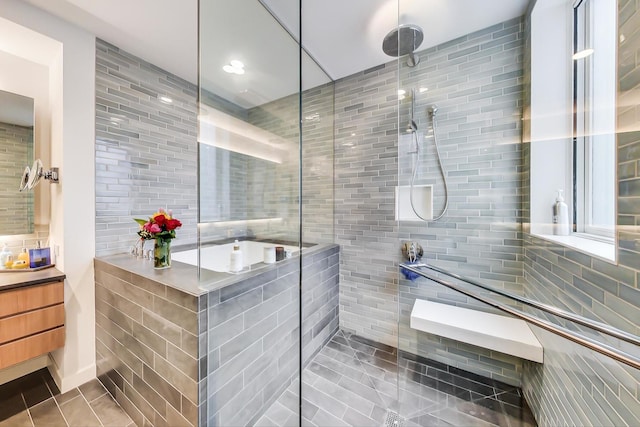 bathroom featuring tile flooring, a shower with shower door, vanity, and tile walls