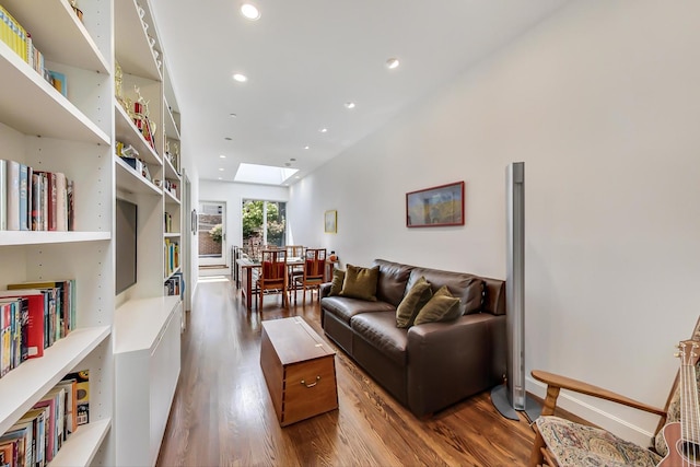 living room with wood-type flooring and a skylight