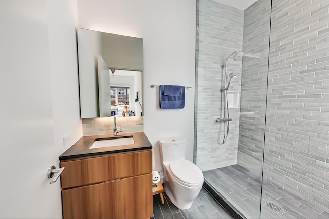 bathroom with a shower with shower door, toilet, tasteful backsplash, and oversized vanity