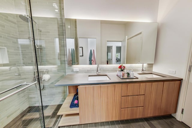 bathroom featuring an enclosed shower, dual vanity, and backsplash