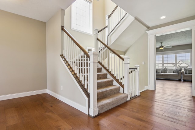 staircase featuring recessed lighting, a ceiling fan, baseboards, and hardwood / wood-style flooring