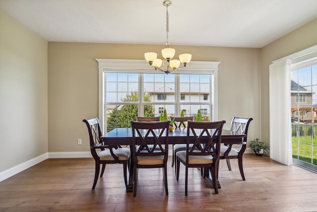 dining area with a chandelier, baseboards, and wood finished floors