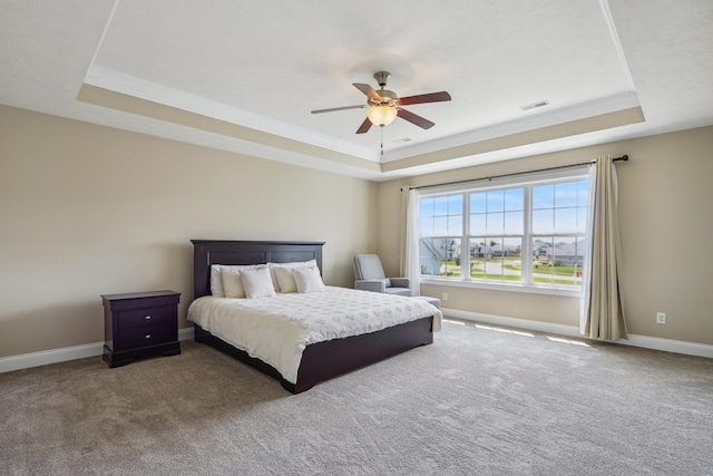 carpeted bedroom with visible vents, crown molding, baseboards, a raised ceiling, and a ceiling fan